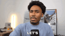 a man is holding a microphone and saying let 's