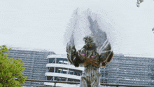a statue of a tiger with wings is standing in front of a building with scaffolding