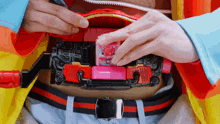 a person is holding a toy on their stomach that says ' a ' on the front