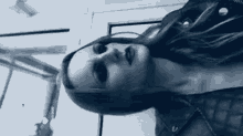 a black and white photo of a woman wearing a leather jacket and makeup .