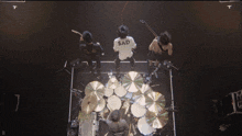 a man in a sad shirt stands in front of a drum kit