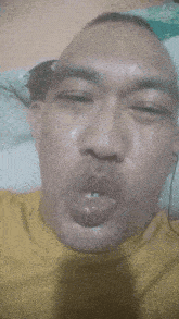 a man in a yellow shirt making a funny face