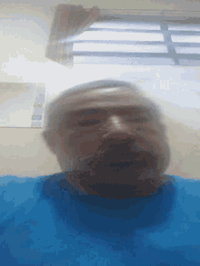 a blurry picture of a person 's face with a blue shirt on