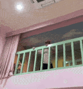 a person standing on a balcony with a calvin klein shirt on