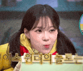a girl with pigtails is making a funny face in front of a sign that says ' bbc ' on it
