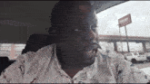 a man sitting in a car in front of a cherry store