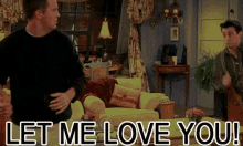 two men are standing in a living room with the words let me love you