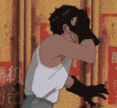 a man in a white tank top is covering his face