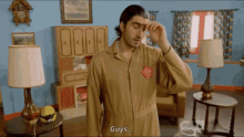 a man in a brown jumpsuit says guys