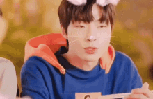 a close up of a young man wearing a cat mask while eating food .