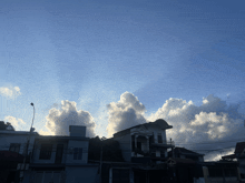 the sun shines through the clouds over the buildings