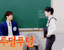 two young men are standing in front of a blackboard with chinese writing on it
