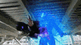 a person in a purple suit is standing in a dark room with a blue light behind them