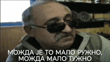 a man with a mustache wearing sunglasses and a caption that says ' mogua je to malo '