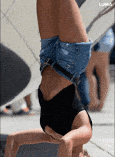 a woman doing a handstand in front of a luma ad