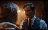 a man in a suit and tie is standing next to a woman with snow on her hair .