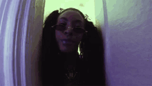 a woman with pigtails wearing sunglasses and a necklace with the letter j on it