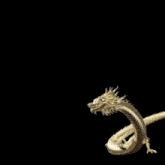 a statue of a golden dragon with the letter s on it 's head