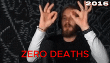 a man with a beard making an ok sign in front of a 2016 zero deaths sign