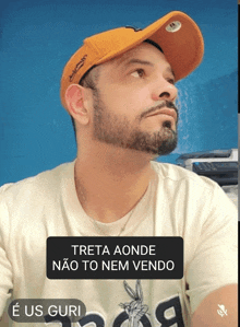 a man with a beard wearing an orange hat and a t-shirt that says e us guri
