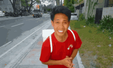 a man wearing a red shirt with a smiley face on the front