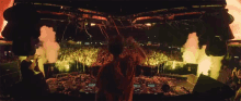 a dj stands in front of a crowd of people at a concert
