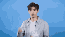 a man in a grey shirt is holding a jar of tissues in front of a blue background that says buzzfeed on it