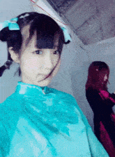 a girl in a blue dress with a blue bow in her hair