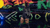 a woman stands in front of a wall that has the word wwe on it