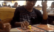 a person playing with a yellow rubber duck in front of a menu