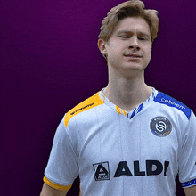 a man wearing a white shirt that says aldi on the front