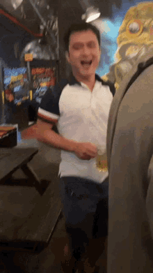 a man in a white shirt is standing in front of an arcade machine that says ' blaze ' on it