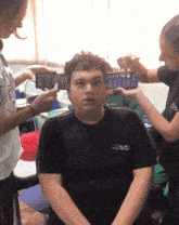 a boy wearing a black shirt that says ' sol est ' on the front