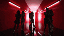a group of women are dancing in a red room