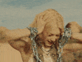 a close up of a woman 's face with chains around her wrists