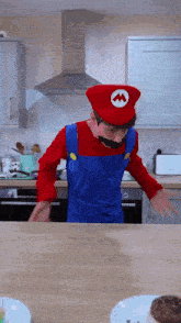 a man dressed in a mario costume is standing in a kitchen
