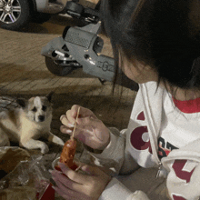 a woman in a gucci sweatshirt is eating a sausage