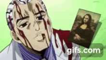 a man with blood on his face is holding a picture of a woman .