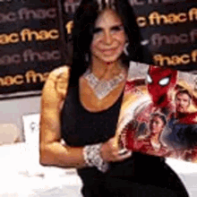 a woman in a black tank top is holding a spider-man comic book .