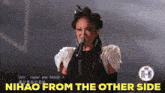 a woman singing into a microphone with the caption " nihao from the other side "