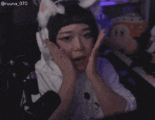 a woman with a surprised look on her face is wearing a cat hat