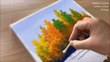 a person is painting a picture with medium yellow lemon yellow and orange colors