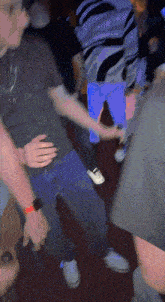 a group of people are dancing in a dark room with a blue background