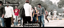 a group of people are walking down a street and one of them says i was just kidding were you scared .