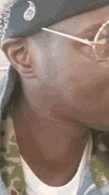 a close up of a man wearing glasses and a bandana .