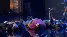 three men are laying on their stomachs on a stage with the word talent behind them