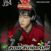 a man wearing headphones and a red manchester united shirt