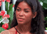 a close up of a woman 's face with flowers behind her