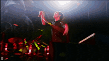 a man singing into a microphone with the letter d in the bottom right corner