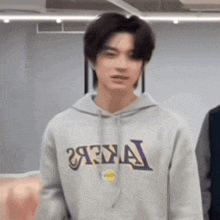 a young man wearing a hoodie that says lakers